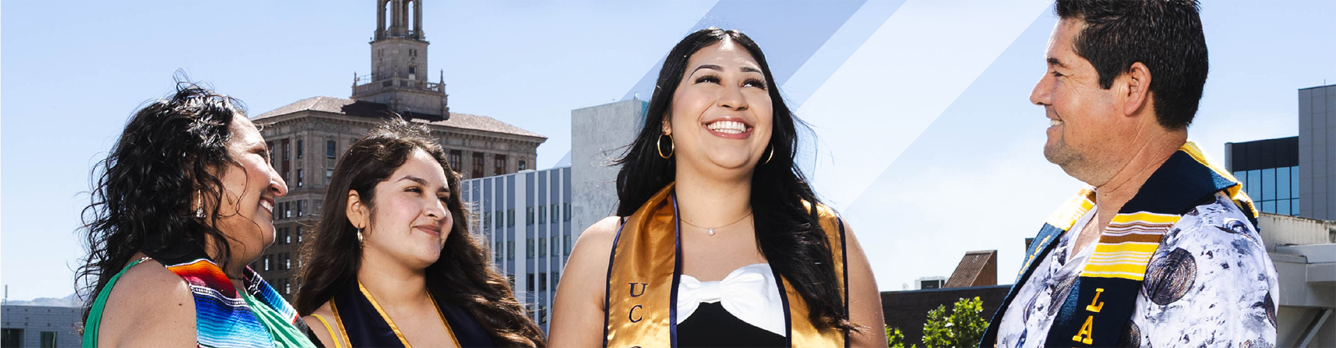 Wide-format photo of a smiling UC Davis graduate in gold regalia celebrating with family members against a sunny Bay Area skyline from the cover of the Students Rising Above annual report